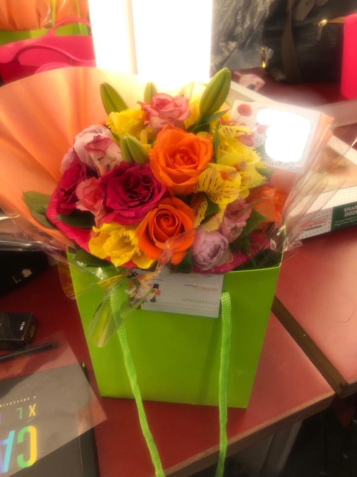 Flower arrangement presented in a green gift box