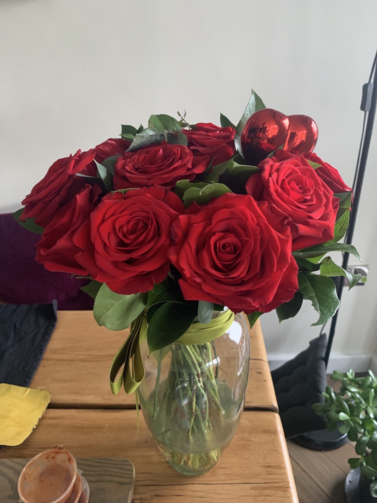 Red roses with foliage arranged in a glass vase